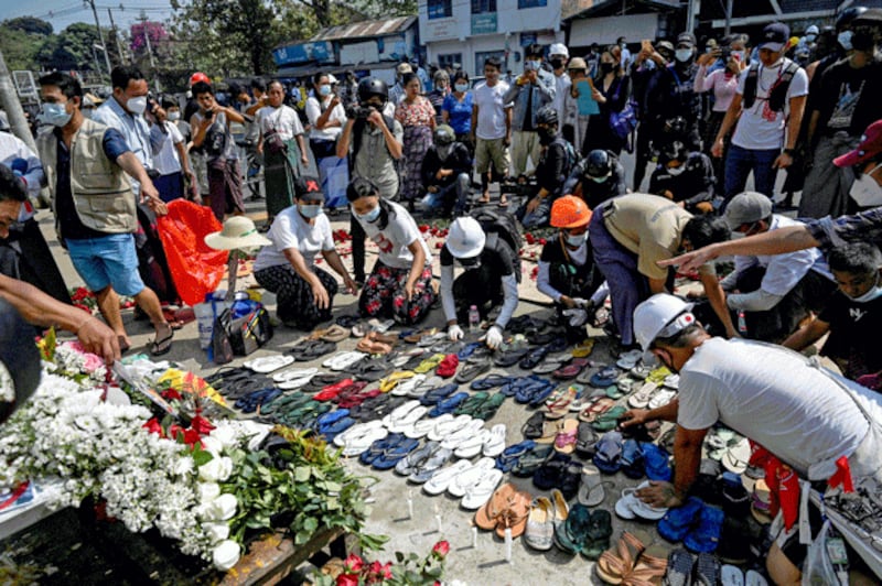 Protesters arrange abandoned flip-flops and other belongings next to a makeshift altar for teacher Tin Nwe Yi, left behind during a crackdown in Yangon, Myanmar, on March 1, 2021, after she was killed during a demonstration against the military coup. Credit: AFP