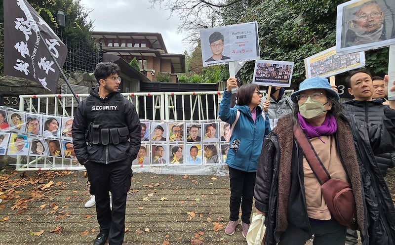 民众在中国驻温哥华领事馆前拉起了四十七人头像的横幅,为他们的无罪发出呐喊。中国领事馆特派出保全维安,保全人员并一直在现场拍照搜证。 (记者柳飞拍摄)