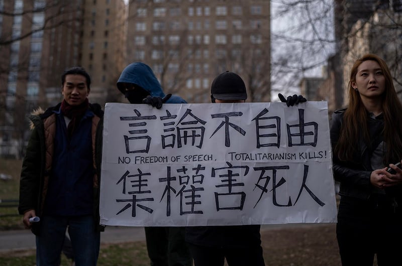 在2023年2月5日于纽约中央公园举行的纪念新冠疫情初起时,率先发出警讯,最后不幸染疫过世的李文亮医师的活动中,华裔抗议者遮蔽脸部,试图掩蔽其身分。(RFA photo/Gemunu Amarasinghe)