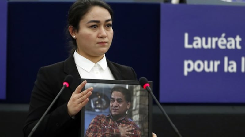 Jewher Ilham holds a photo of her father, Ilham Tohti, during the Sakharov Prize ceremony at the European Parliament, in Strasbourg, France, Dec. 18, 2019. Credit: AP Photo