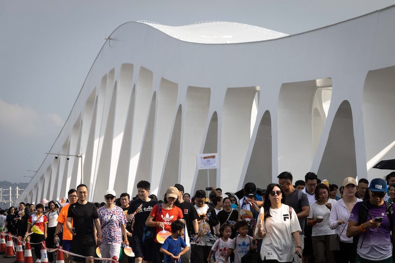 People walk on the newly-opened Macau Bridge, the fourth connection between the Macau peninsula and Taipa island, in Macau on September 29, 2024.