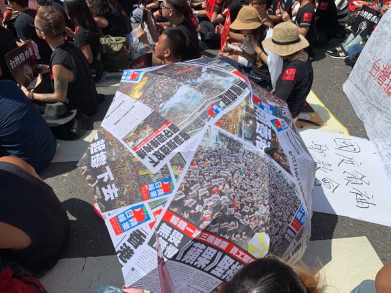 学生发挥创意,以简报自制雨伞“撑”香港。(记者 黄春梅摄)