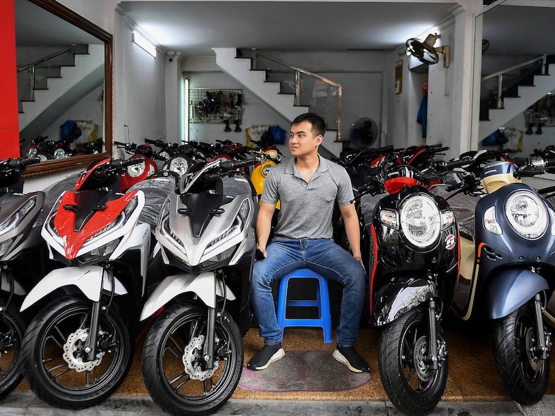 A salesman waits for customers at a motorcycle and scooter showroom in Hanoi, VIetnam, March 29, 2021.