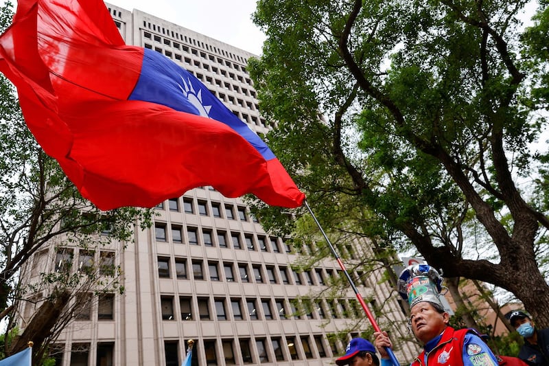 A supporter of the main opposition party Kuomintang (KMT) waves a Taiwanese flag outside of the Central Election Commission in Taipei in 2023. (Ann Wang/Reuters)