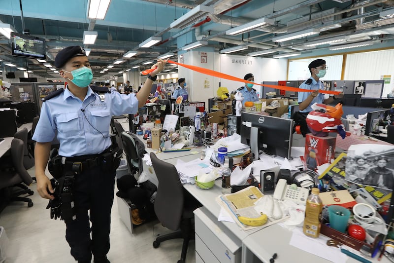 Hong Kong police officers search the office of Apple Daily newspaper on Aug. 10, 2020.